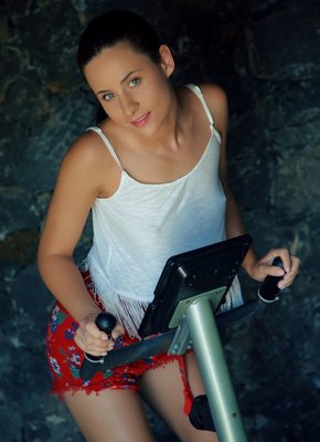 Молодая брюнетка занимается на тренажере